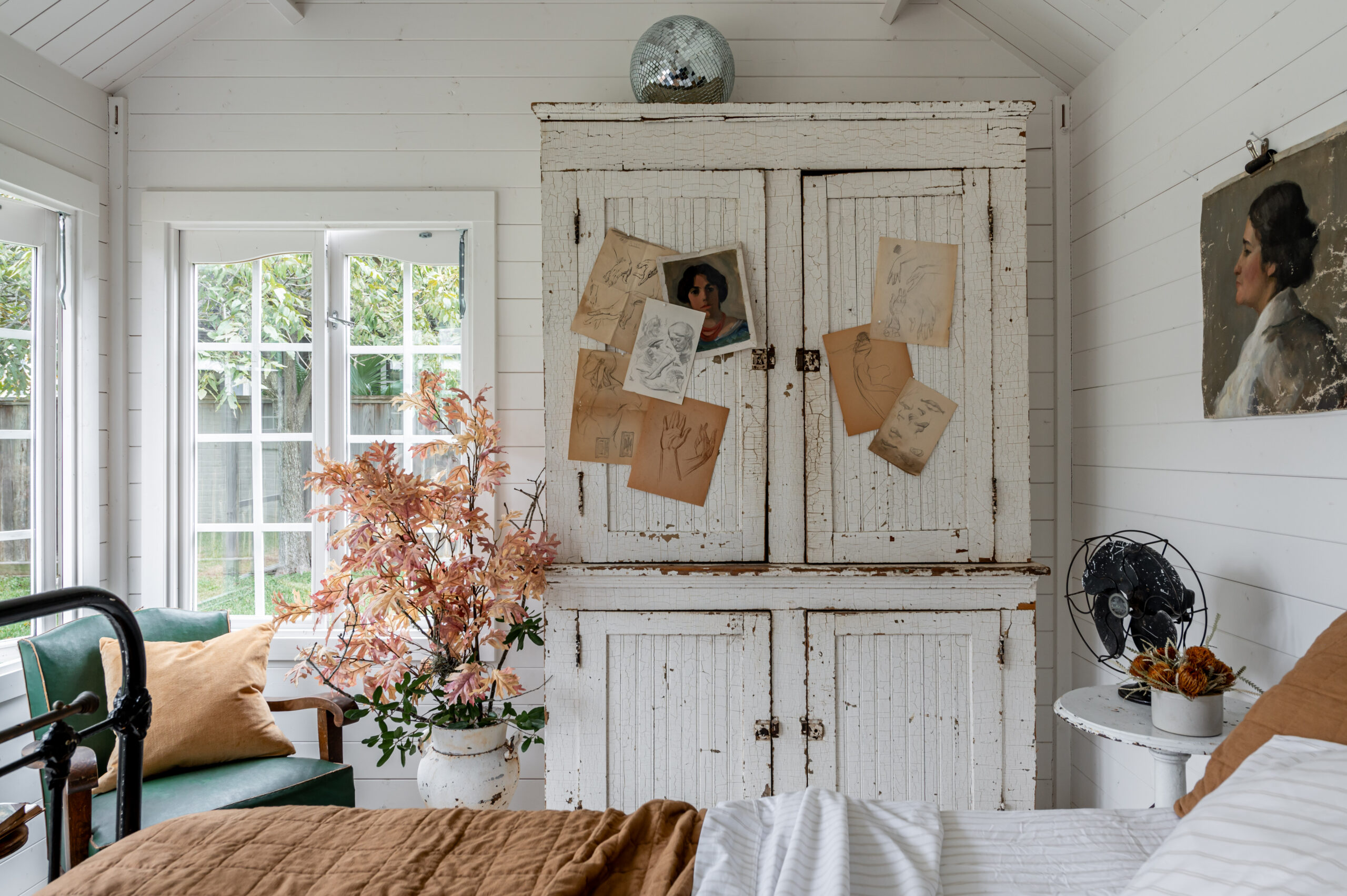 Beautiful bedroom interior with vintage bed frame and bedroom drawer, antique wall art and side table