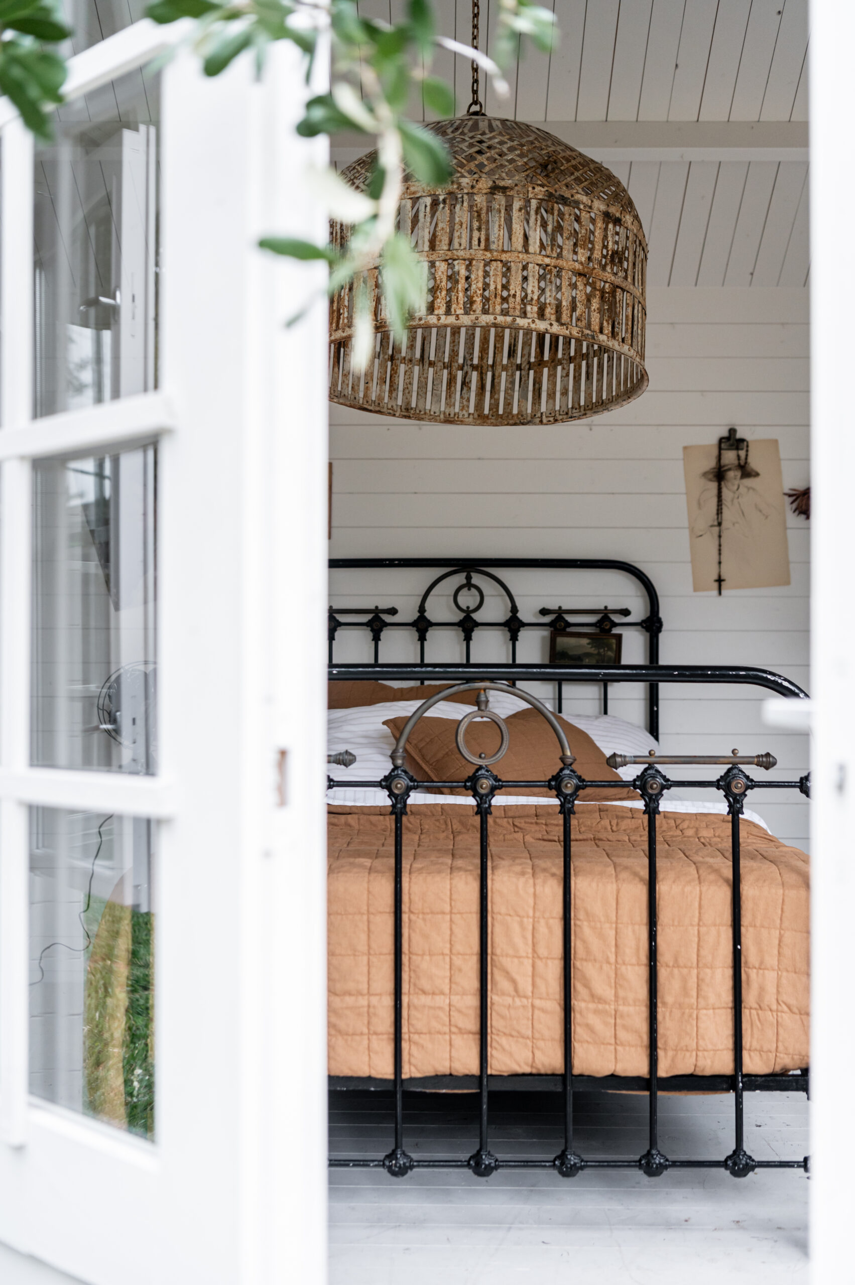 Beautiful bedroom interior with vintage bed frame and light fixture