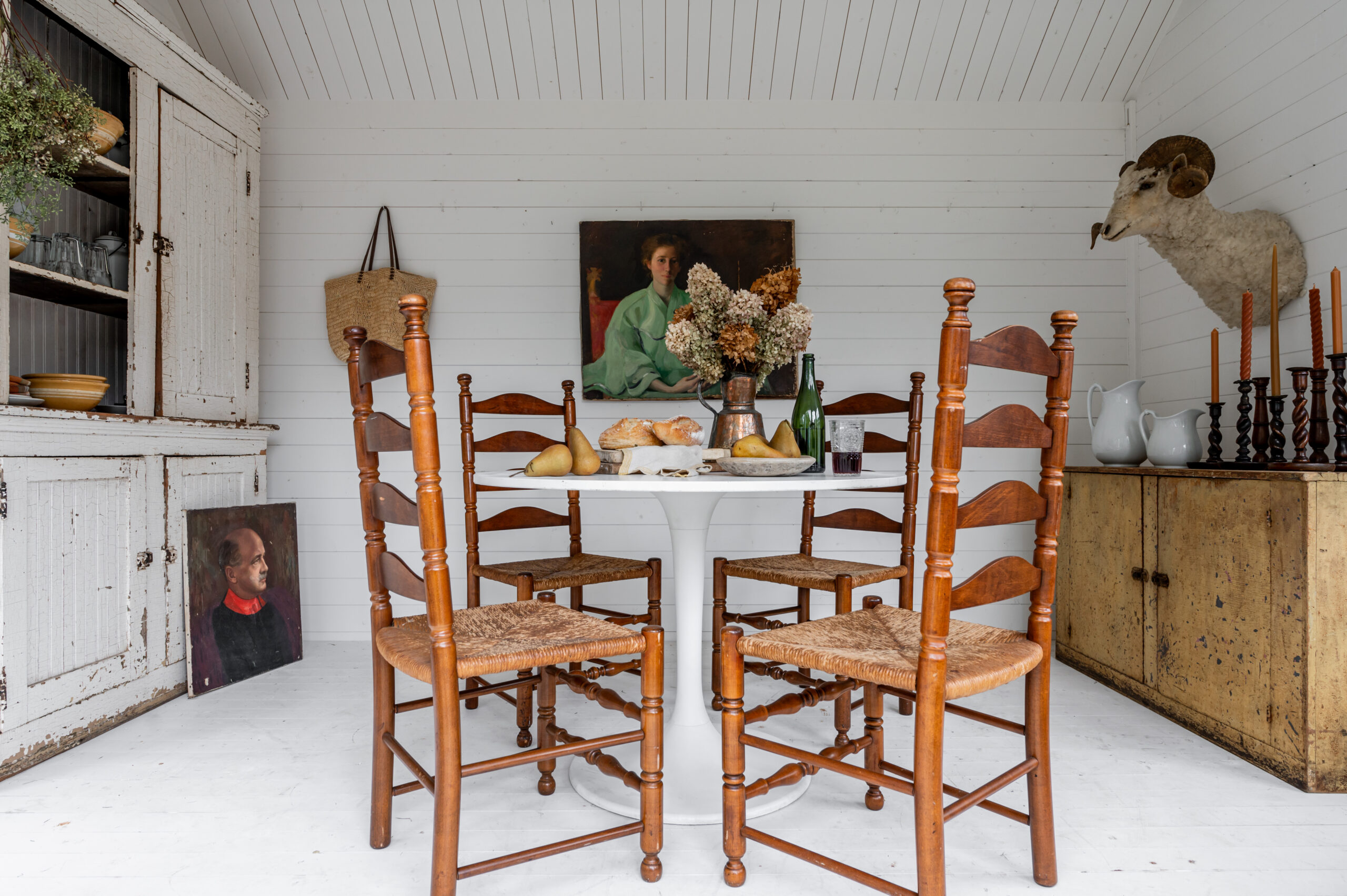 Antique wooden chairs and wall art in a dining room set up