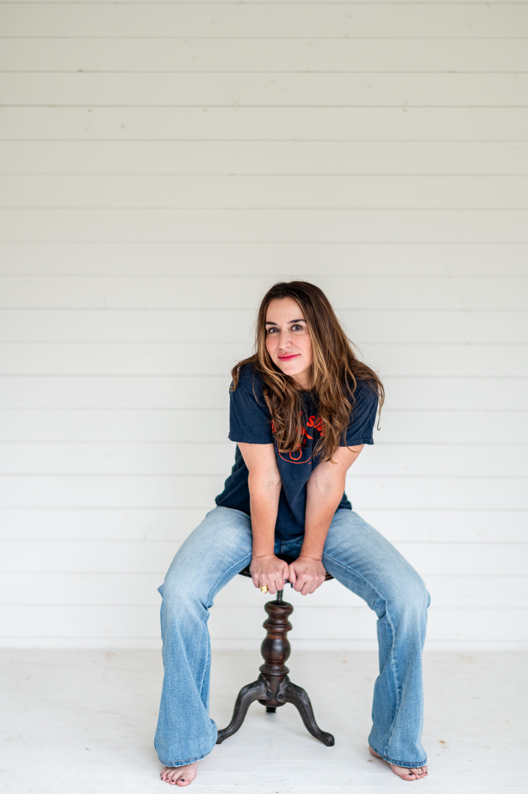 Woman sitting on wooden stool for her business launch photoshoot