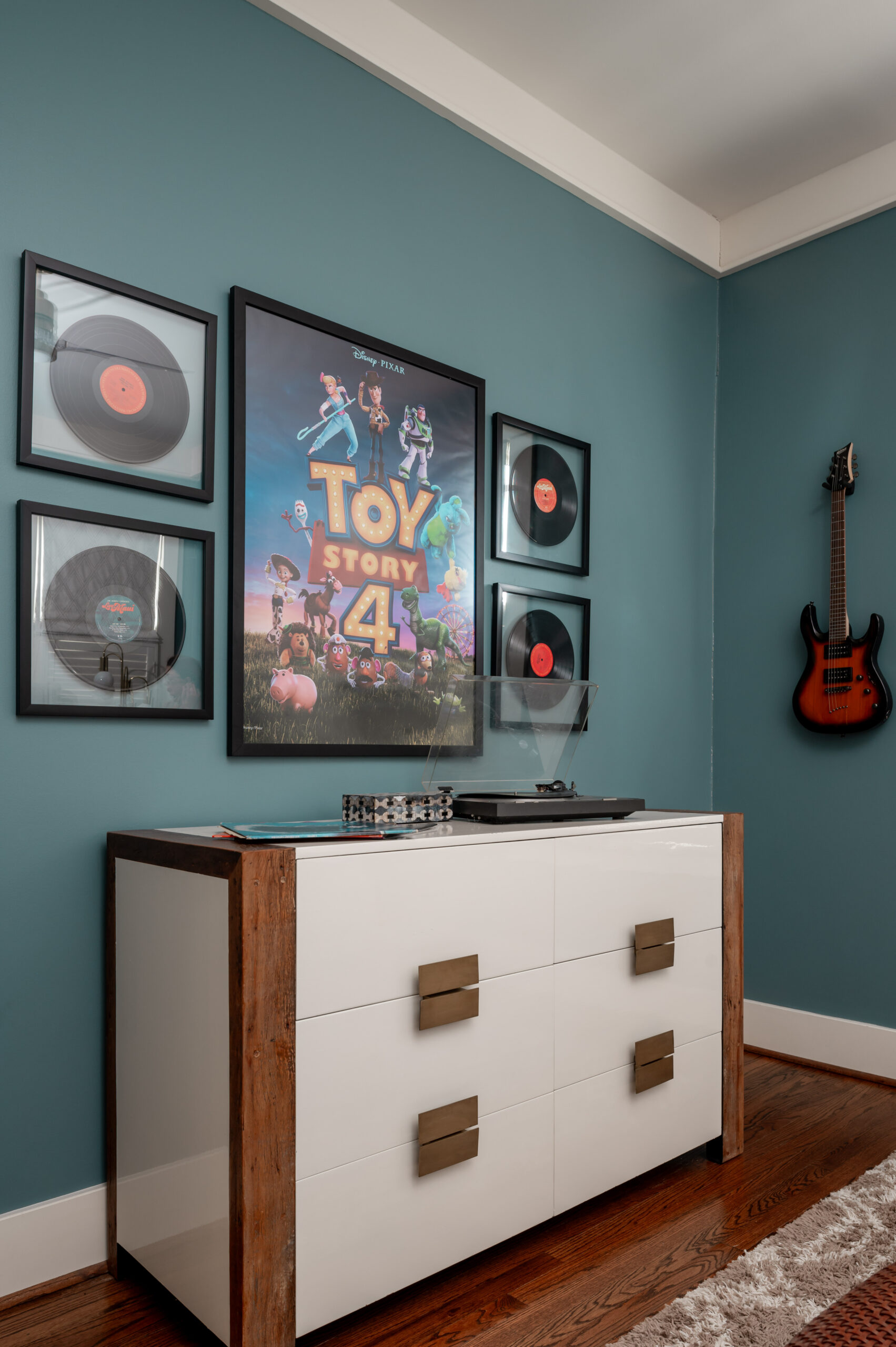 White wooden dresser with Toy Story 4 poster hanging on the wall