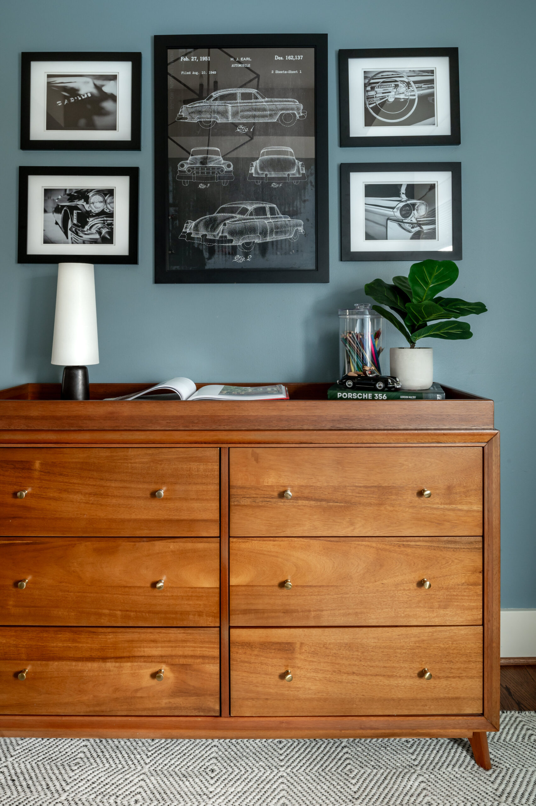 Boys bedroom interior design with wooden dresser and car wall art