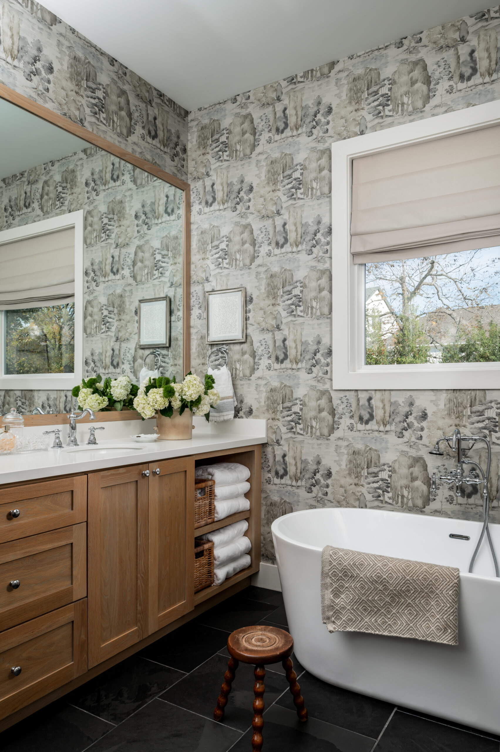 Gorgeous bathroom with wooden cabinets and unique wallpaper