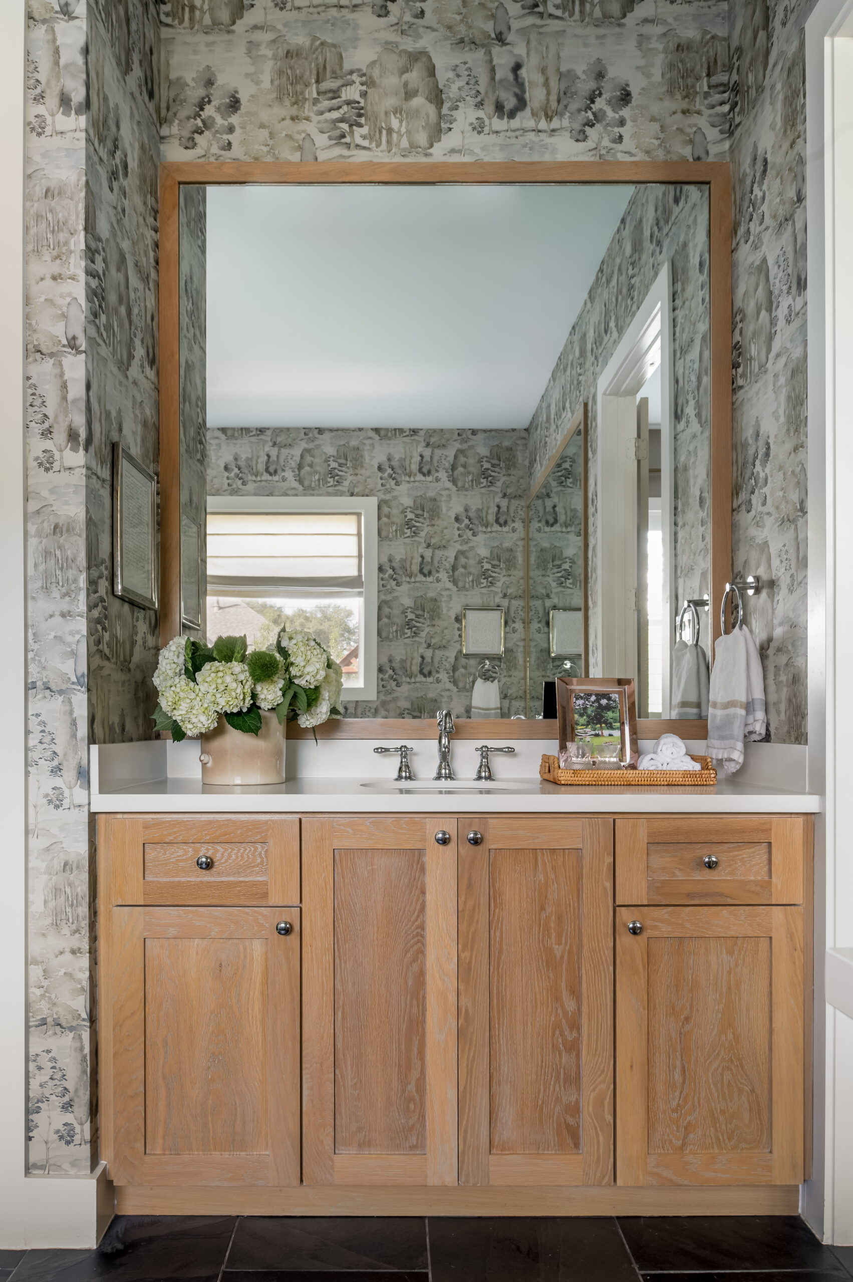 Gorgeous bathroom with wooden cabinets and unique wallpaper