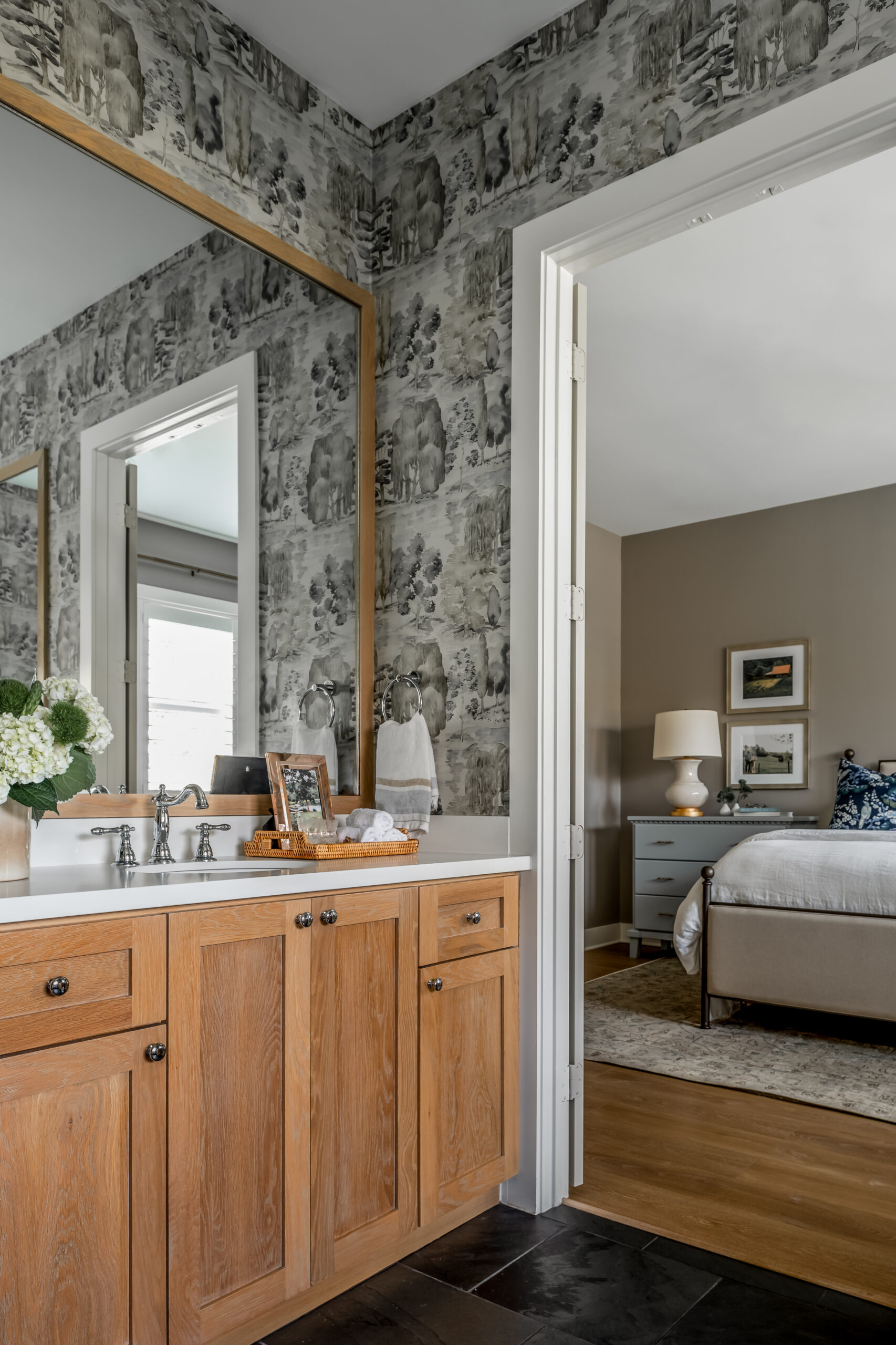 Gorgeous bathroom with wooden cabinets and unique wallpaper