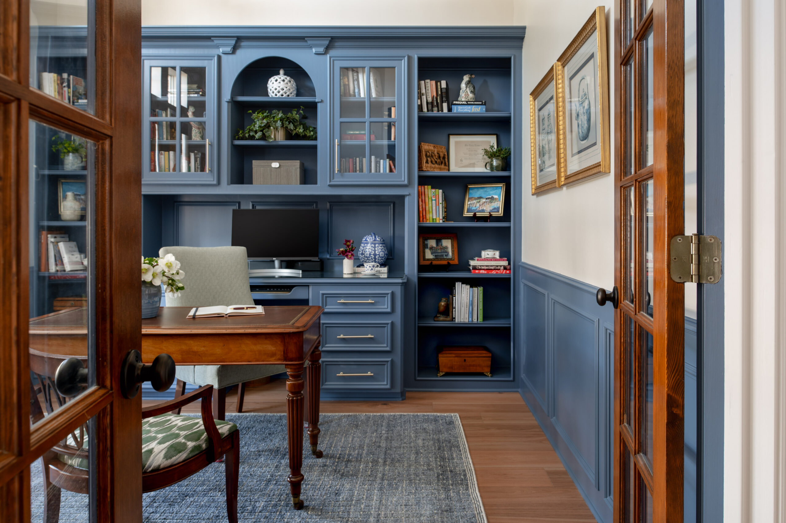 Beautiful office interior design with blue book case and wooden desk and chair