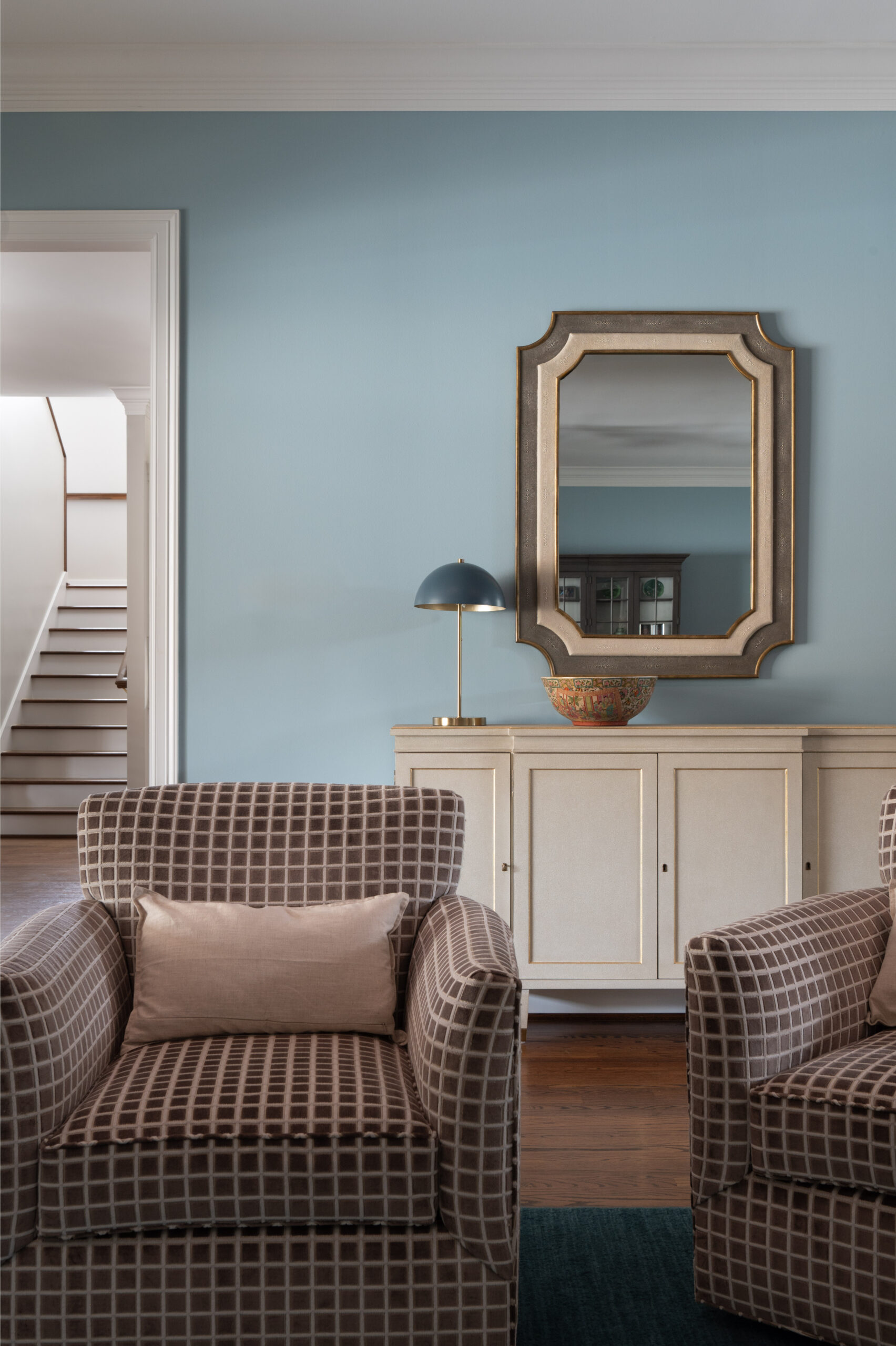 Living room interior design photo of plaid chairs and blue wall