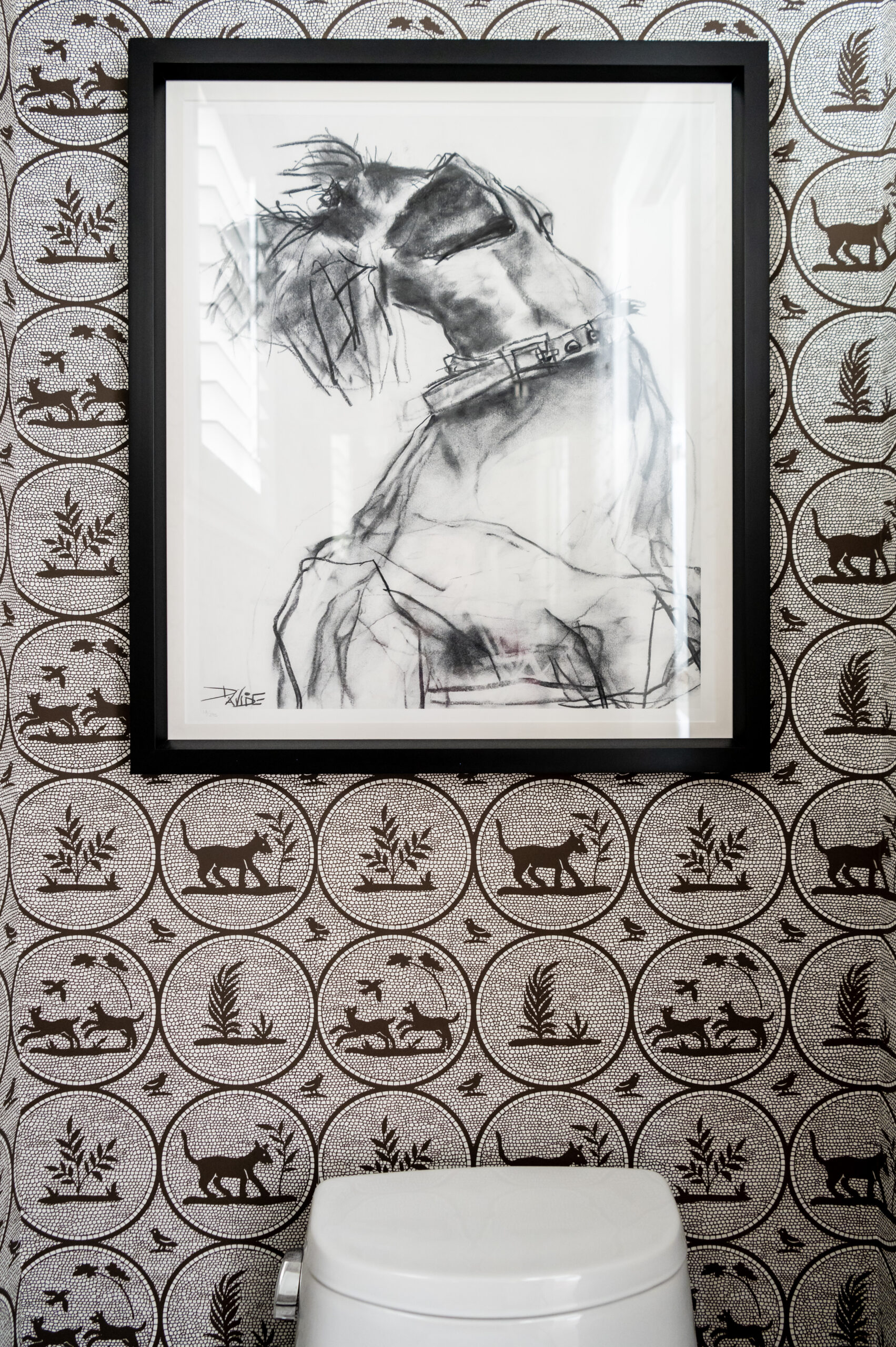 Bathroom interior design photo of unique bathroom wallpaper and picture frame hanging over the toilet