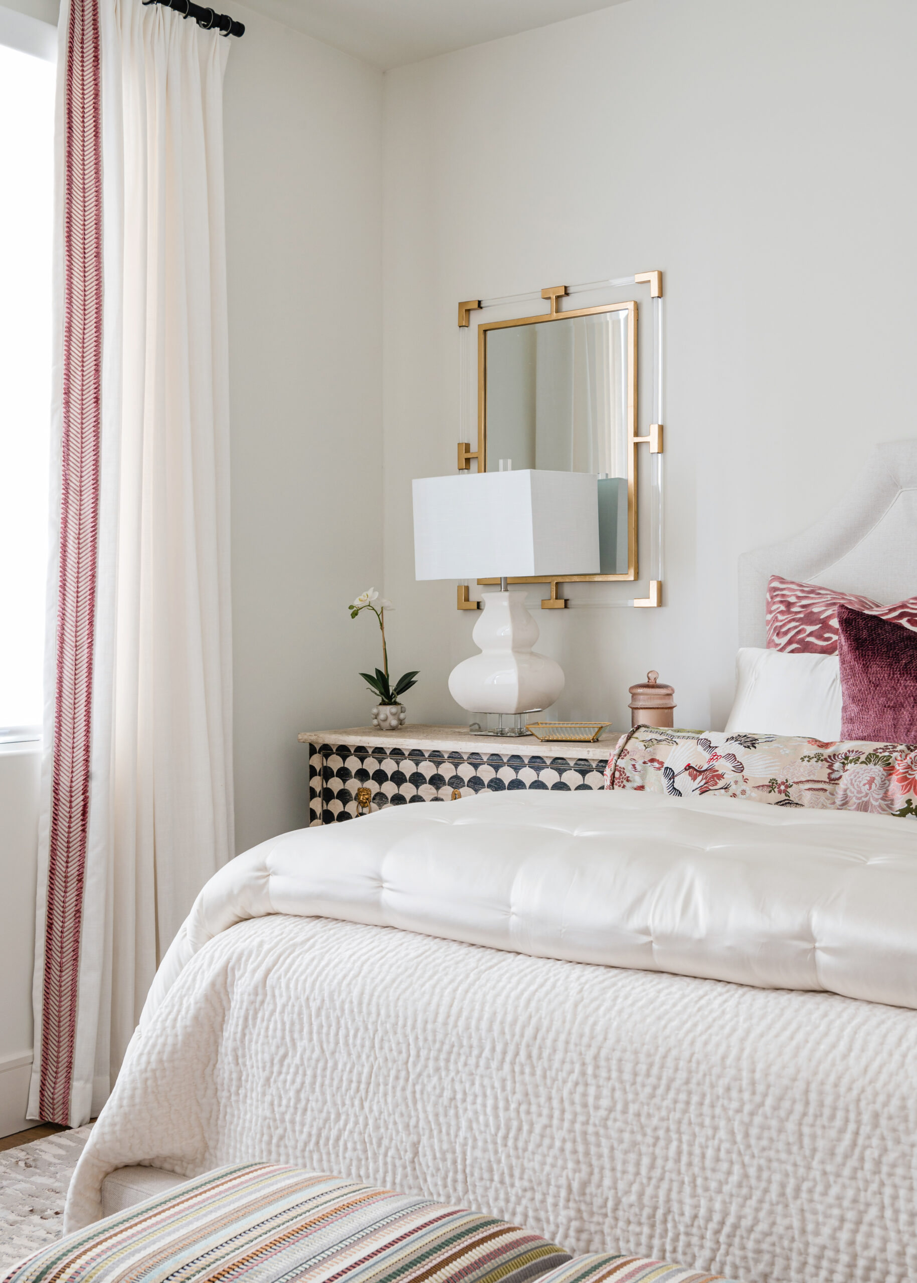 A cozy bedroom with plush textures and patterned pillows, showcasing vibrant textiles and attention to detail characteristic of Texas interior design.