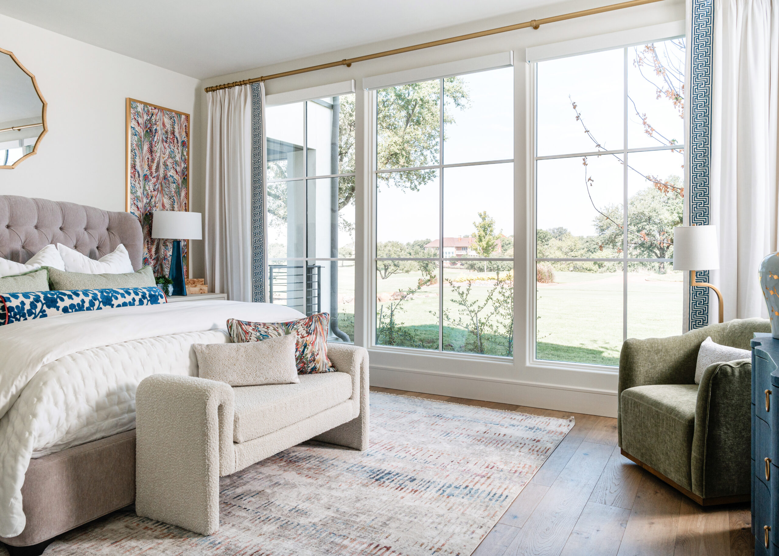 A serene master bedroom with expansive windows, offering views of the outdoors and blending indoor elegance with outdoor beauty for photographing interiors shoot