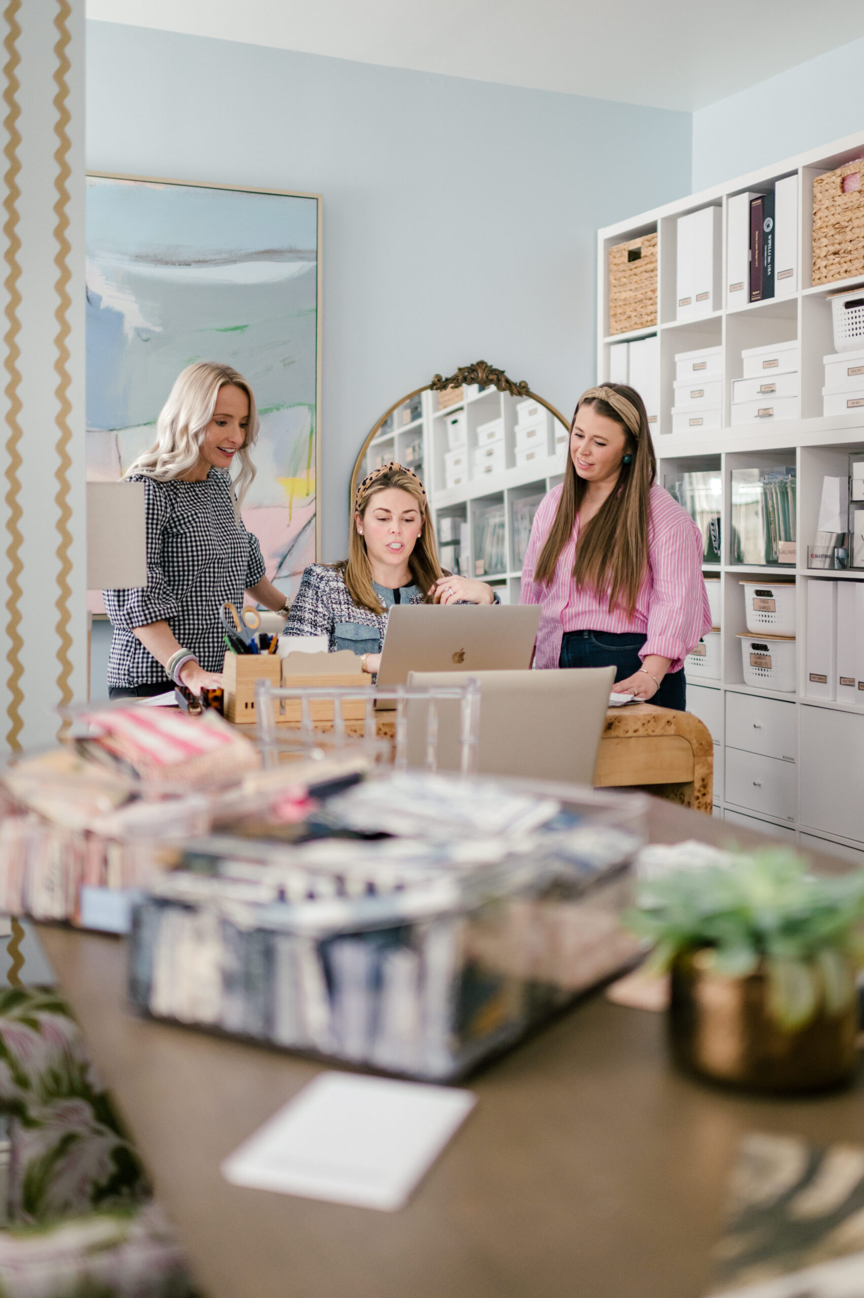 Three interior designers discussing their plans in a bright and organized office space. This workspace exemplifies how professional interiors can enhance productivity and creativity. Mastering interior design starts with attention to detail in every aspect of your space!