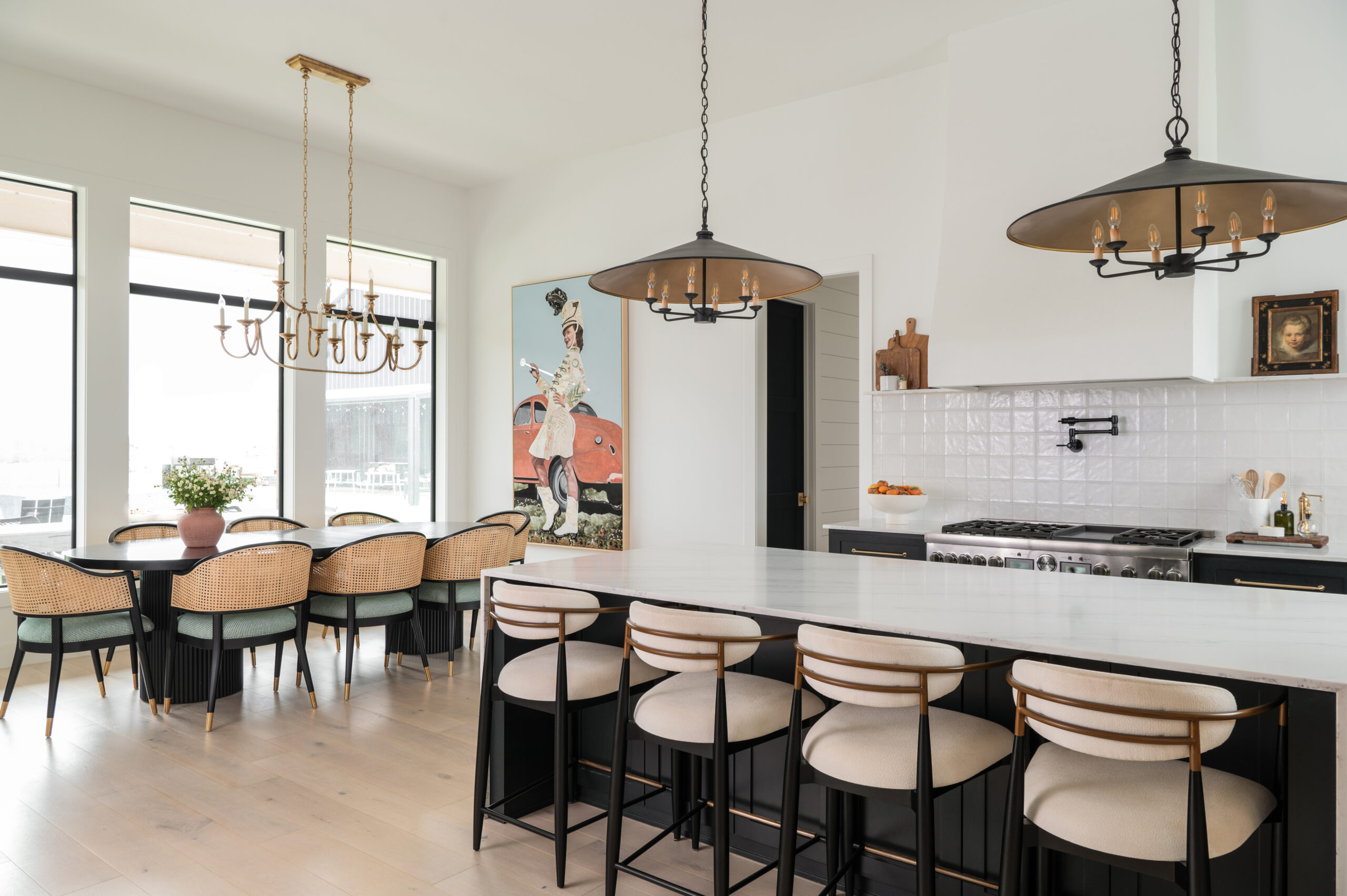 Modern home interior design with a sleek kitchen featuring stylish bar stools and a spacious dining area with elegant light fixtures.