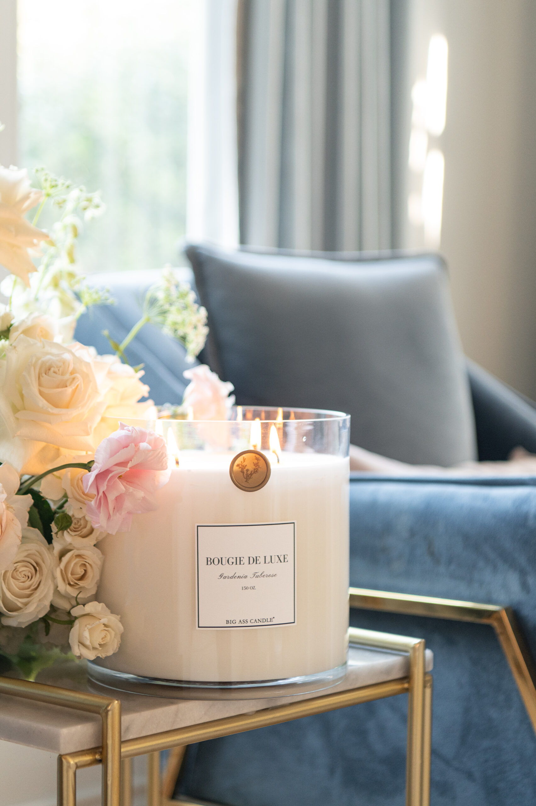 close-up of beautiful floral arrangements with a candle, elegantly arranged in a living room corner, highlighting the soft glow and serenity in seasonal photography.