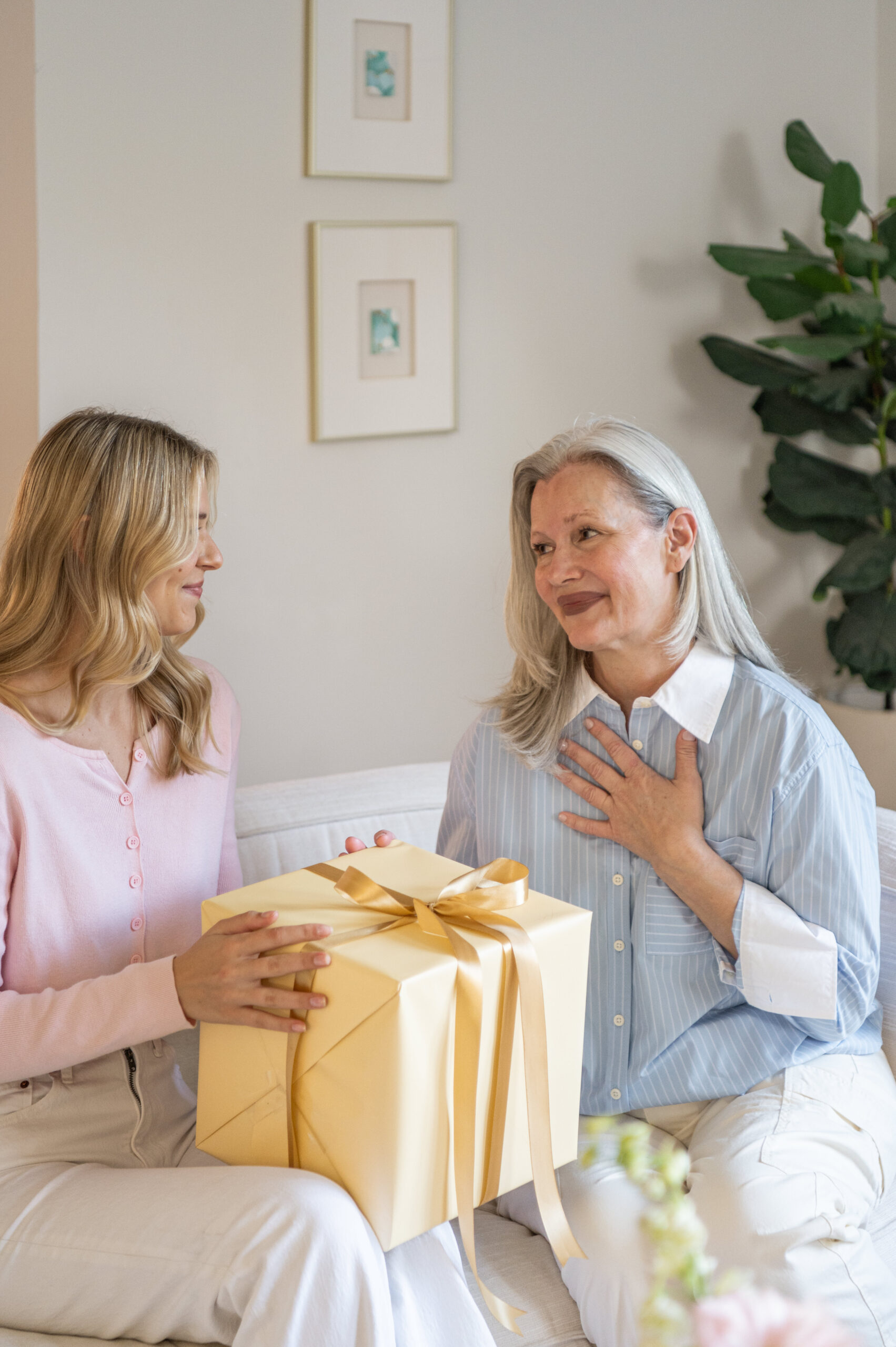  A heartfelt moment between a mother and daughter exchanging a gift, a perfect capture for seasonal photography celebrating family love and gifting traditions.