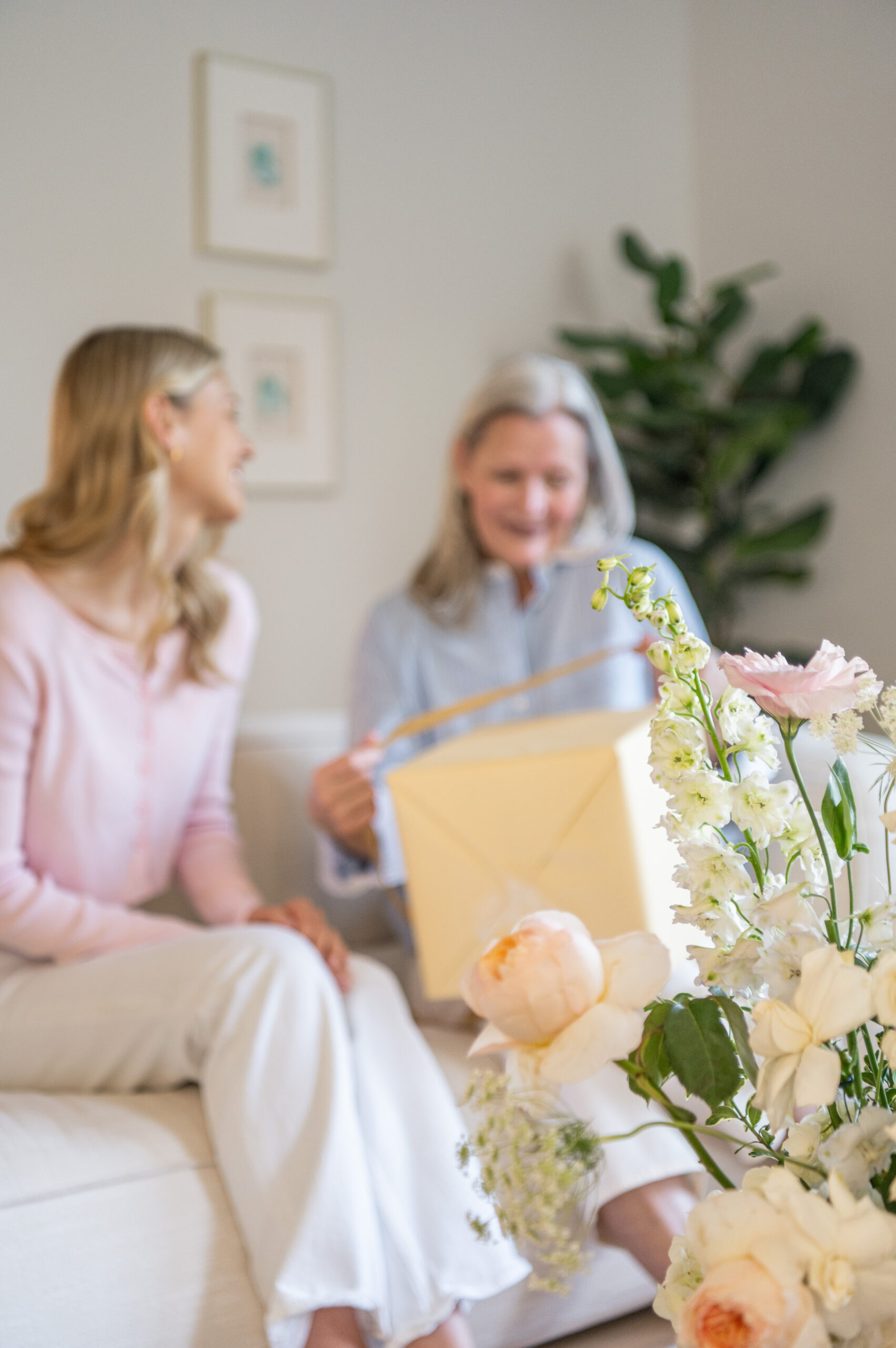 A heartfelt moment between a mother and daughter exchanging a gift, a perfect capture for seasonal photography celebrating family love and gifting traditions.