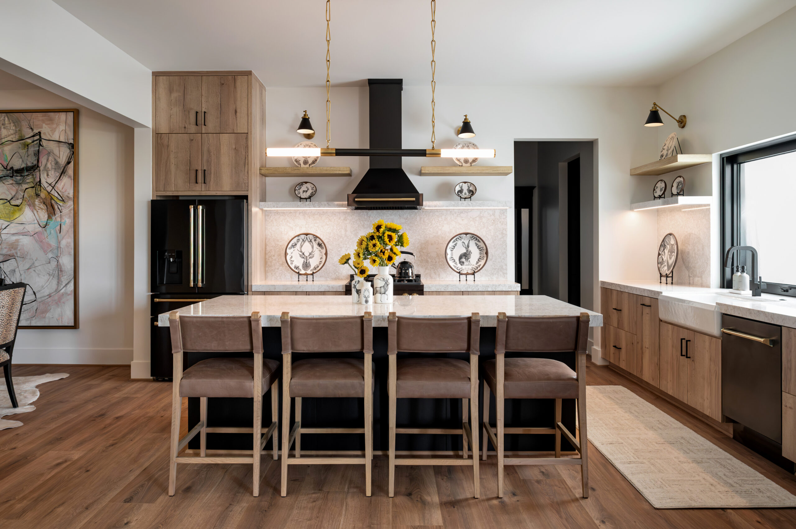 Visual storytelling photography of a curated kitchen space featuring a central island, sunflower bouquet, and artistic animal-themed plates adding character and warmth to a clean layout.