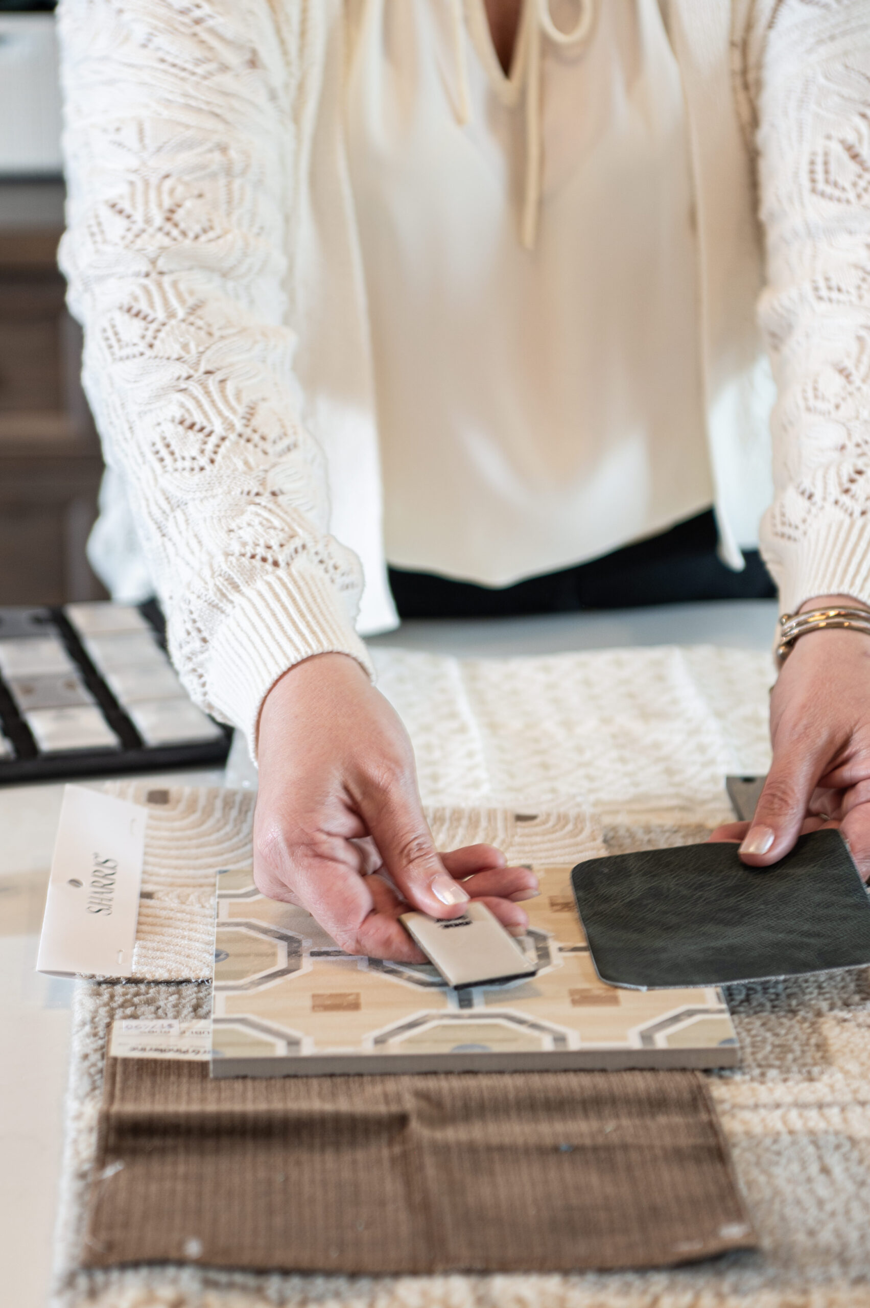 Close-up of an interior designer arranging material and color swatches during a design planning session, reflecting the creative process behind brand photography.