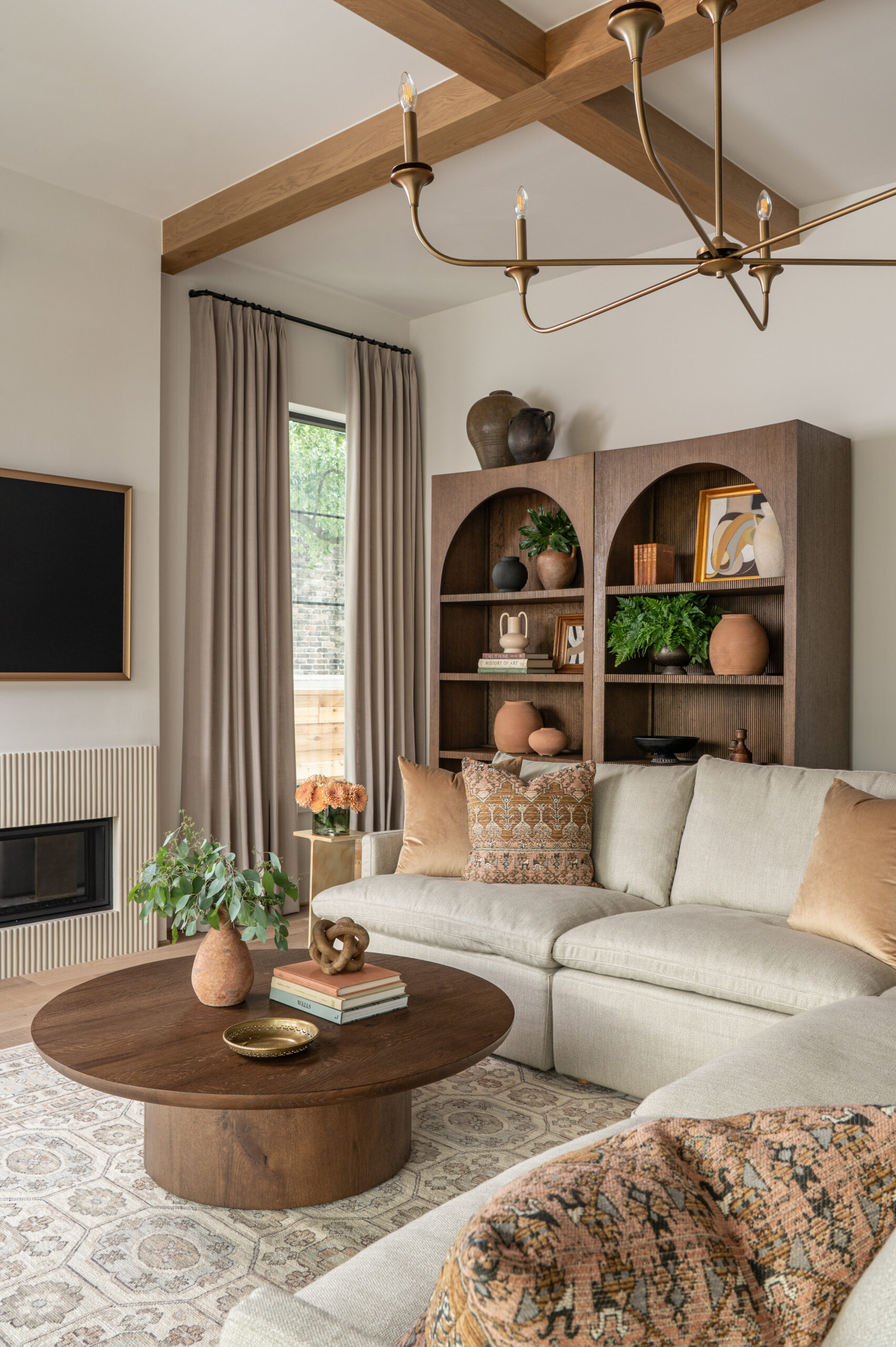 A warm-toned family room with a linen sectional, rustic wood bookshelves, and woven baskets—illustrating how texture in interior design adds depth and character.