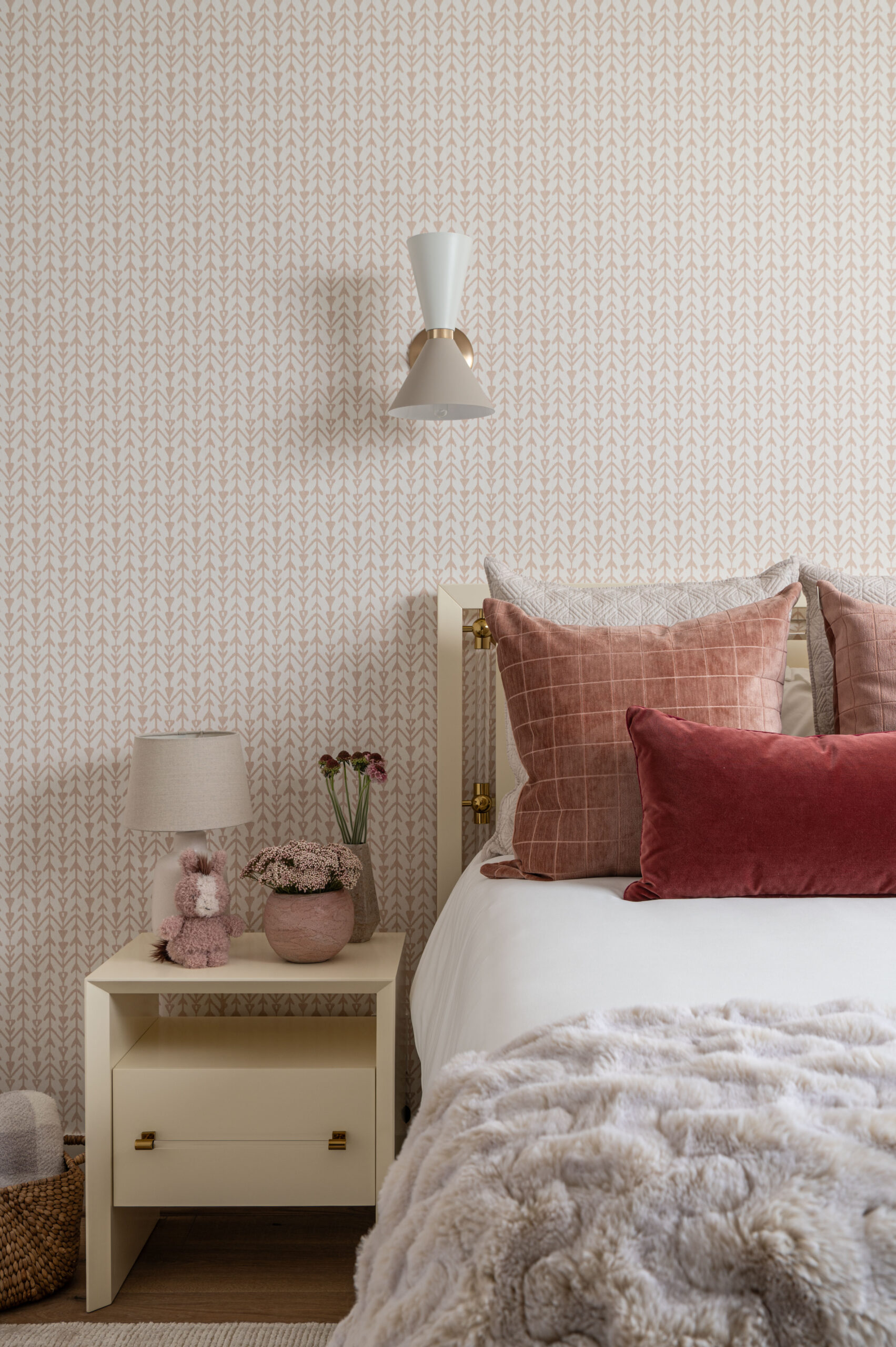 A bedroom styled with layered textiles including faux fur, crisp cotton, and velvet pillows, showing how texture in interior design creates a sense of comfort and personality.